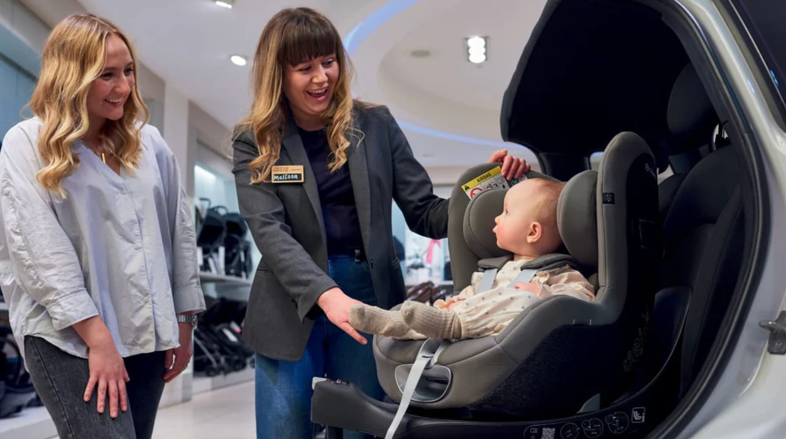 Expert fitting a car seat for a customer